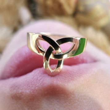 Handcrafted Irish Jewellery Designed Trinity ring | Irish Jewellery| 
Photograph of a Handcrafted Irish Celtic ring balance on the models lips 